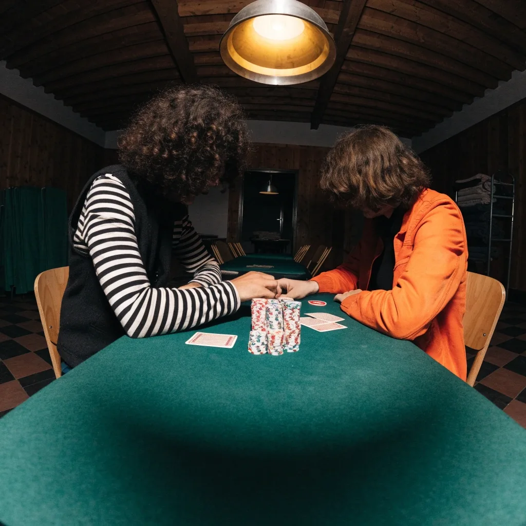 Pohled na pokerový stůl seshora během sehrávky, žetony a karty